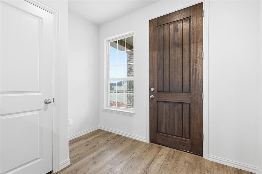 Foyer featuring light wood-style floors and baseboards