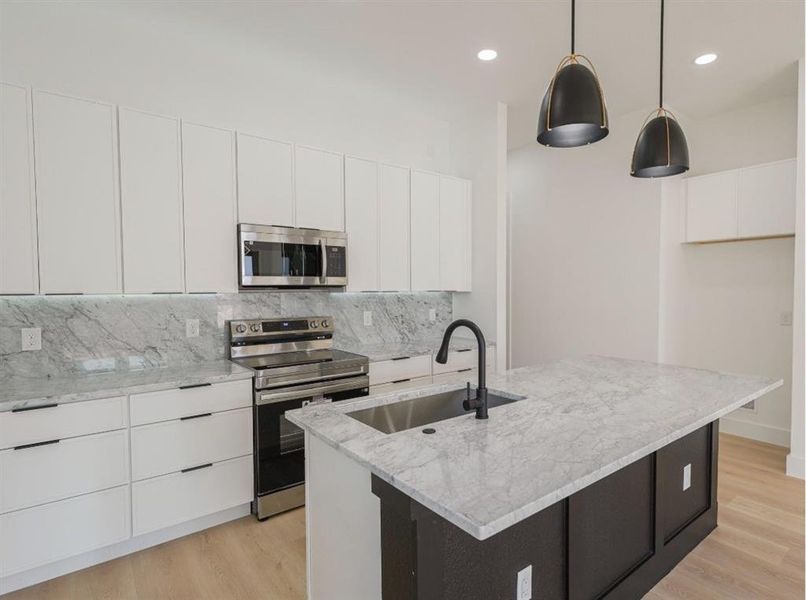 Kitchen featuring white cabinets, stainless steel appliances, decorative backsplash, modern cabinets, and recessed lighting Kitchen featuring white cabinets, stainless steel appliances, decorative backsplash, modern cabinets, and recessed lighting