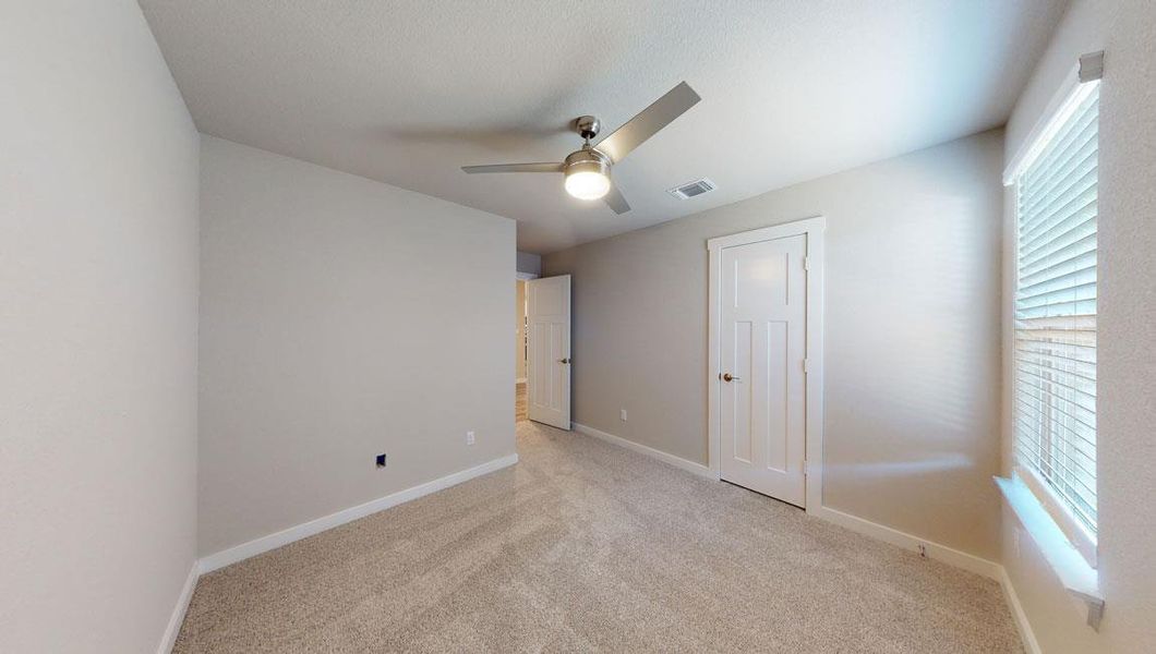 Unfurnished bedroom featuring light colored carpet and ceiling fan