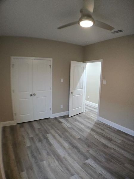 Unfurnished bedroom with ceiling fan, a closet, and light hardwood / wood-style flooring