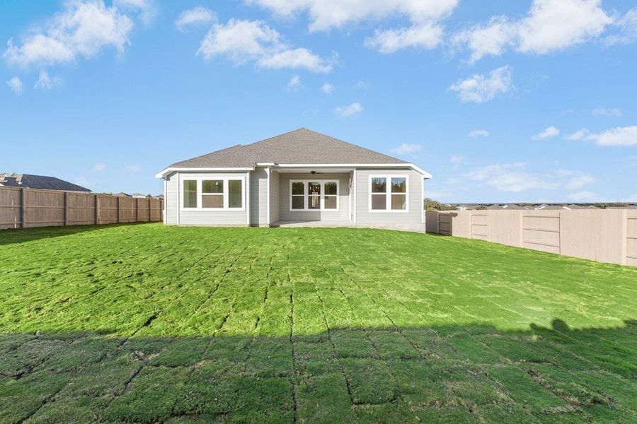 Rear view of property featuring a patio, ceiling fan, a fenced backyard, and roof with shingles