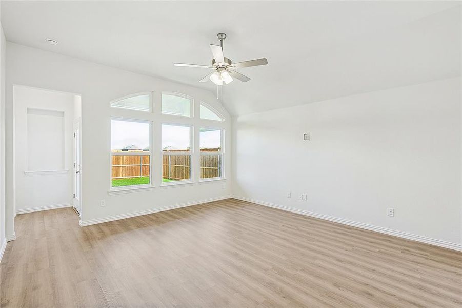 Unfurnished living room with ceiling fan, light hardwood / wood-style floors, and vaulted ceiling