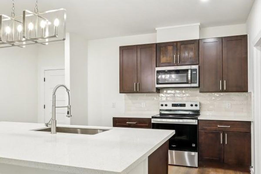 Modern kitchen featuring sleek dark wood cabinets, stainless steel appliances, and elegant lighting. Perfect for culinary creativity and entertaining. Modern kitchen featuring sleek dark wood cabinets, stainless steel appliances, and elegant lighting. Perfect for culinary creativity and entertaining.