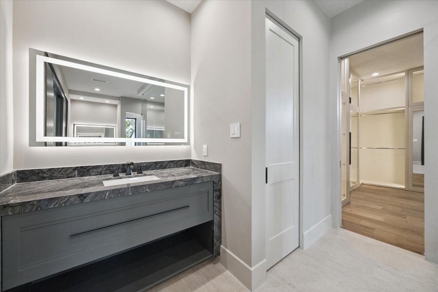 Flanking the space are dual private water closets for added convenience and privacy.