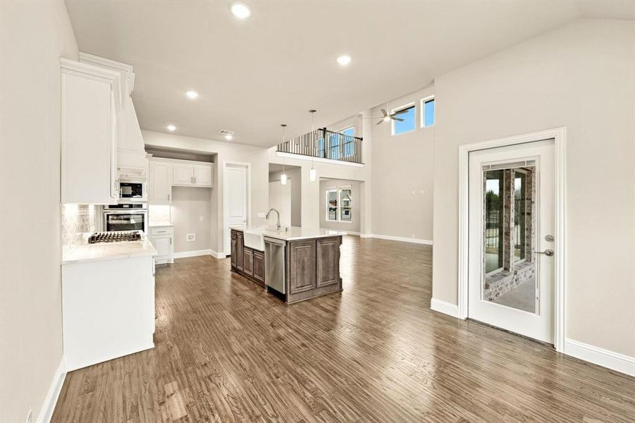 Kitchen featuring white cabinets, open floor plan, a kitchen island with sink, ceiling fan, and recessed lighting