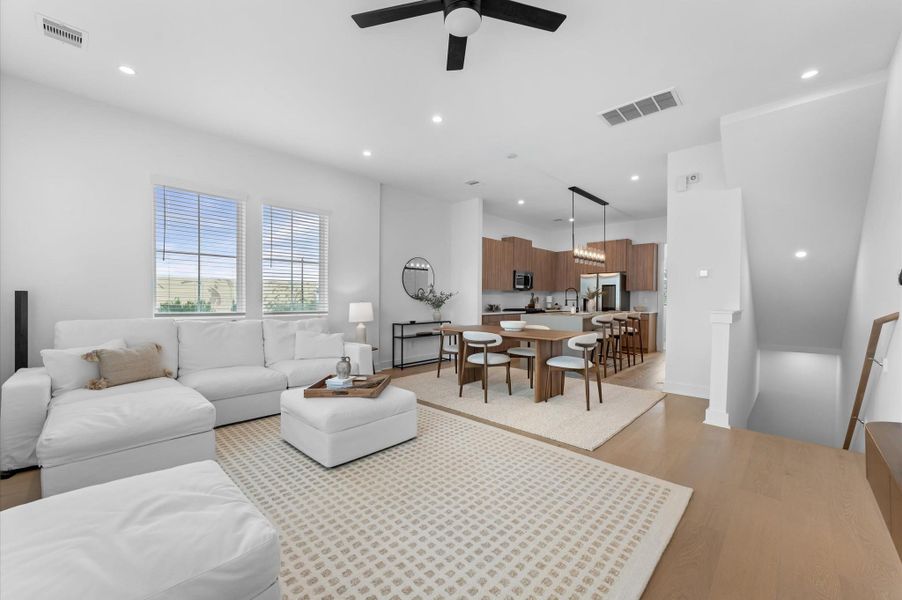 The second floor boasts a spacious open-concept living, dining, and kitchen area filled with natural light from abundant windows, featuring sleek modern finishes and warm engineered hardwood floors that create the perfect blend of style and comfort for everyday living and entertaining.