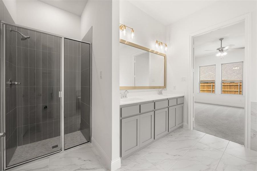 Full bathroom with marble look tiles, double vanity, tiled shower, and ceiling fan Full bathroom with marble look tiles, double vanity, tiled shower, and ceiling fan
