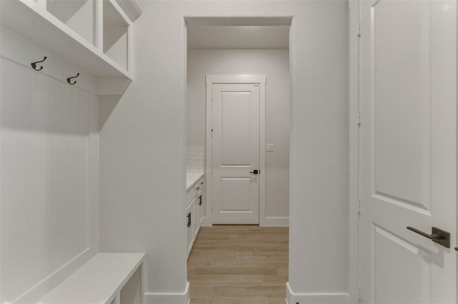 Mudroom with built-in bench seating, upper shelving, and coat hooks Mudroom with built-in bench seating, upper shelving, and coat hooks