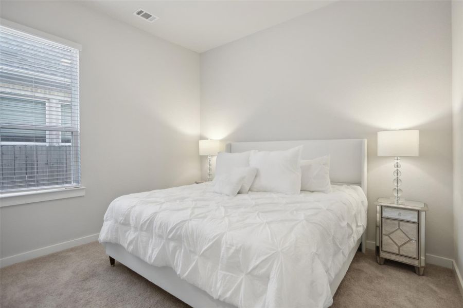 Carpeted bedroom with visible vents and baseboards