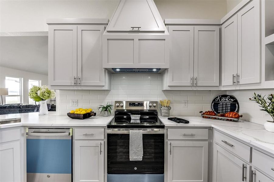 Kitchen featuring appliances with stainless steel finishes, white cabinetry, and decorative backsplash