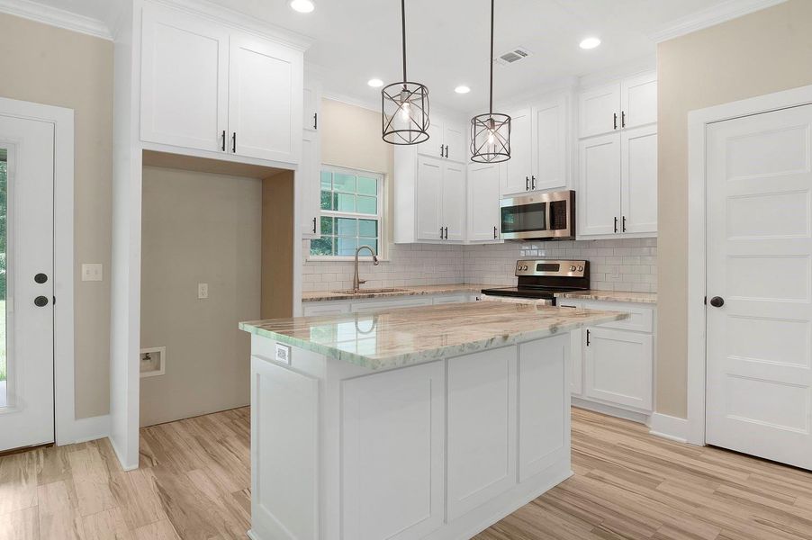 Bright, modern kitchen with white cabinetry, sleek stainless steel appliances, and a spacious marble island. Features stylish pendant lighting, subway tile backsplash, and wood-look flooring, creating a warm and inviting atmosphere. Bright, modern kitchen with white cabinetry, sleek stainless steel appliances, and a spacious marble island. Features stylish pendant lighting, subway tile backsplash, and wood-look flooring, creating a warm and inviting atmosphere.