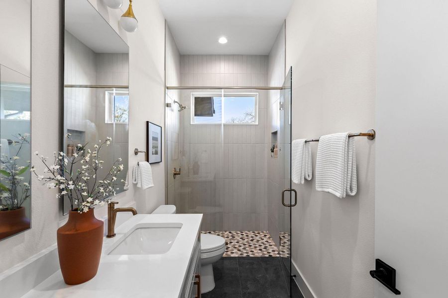 Full bath featuring vanity, a shower stall, and dark tile patterned flooring