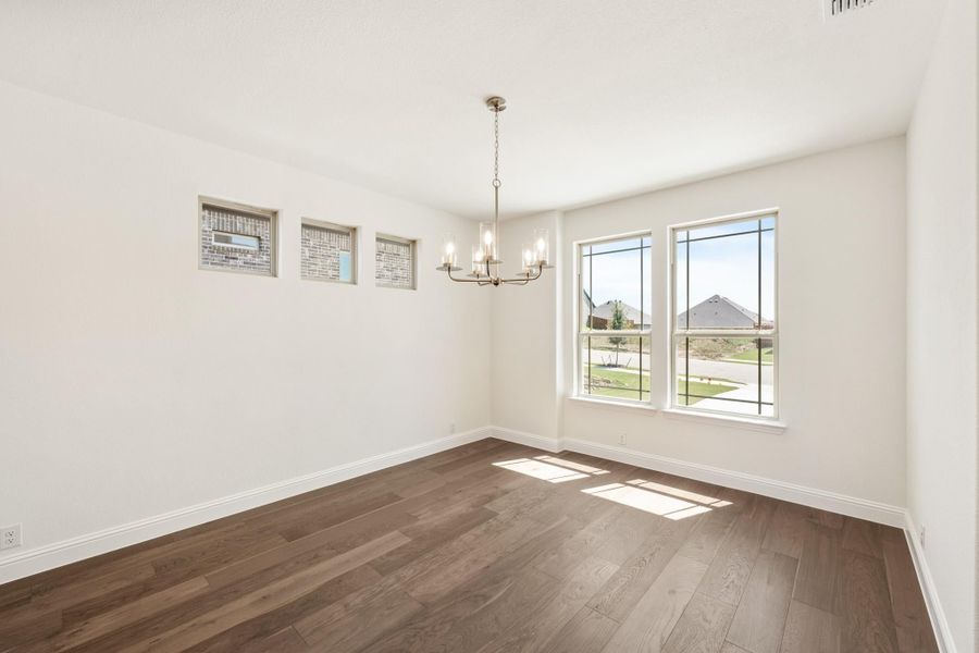 Empty dining room with dark hardwood floors, chandelier, and large windows with neighborhood view Empty dining room with dark hardwood floors, chandelier, and large windows with neighborhood view