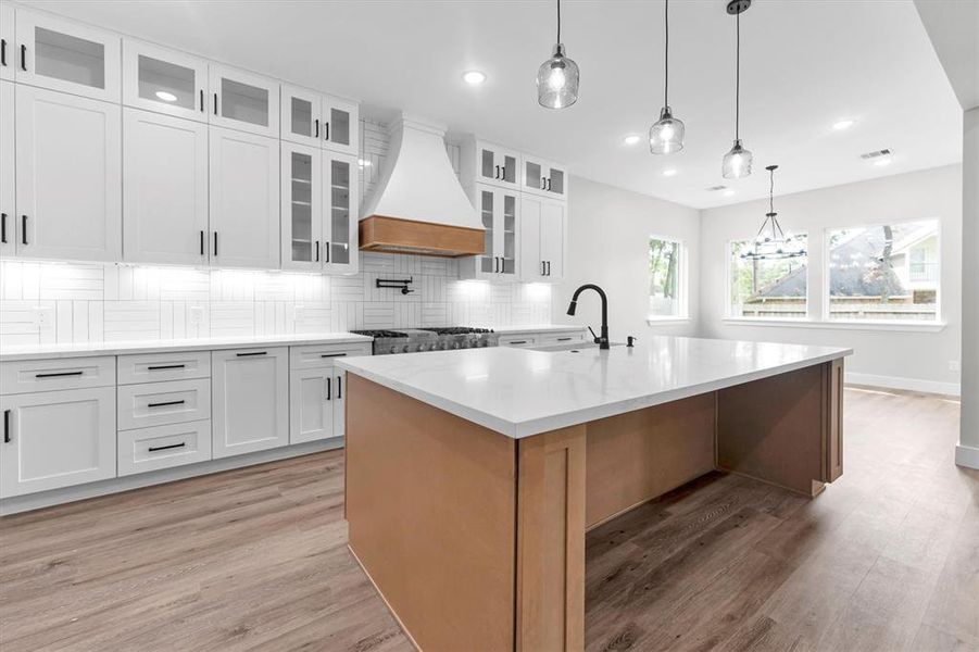 Light filled dining area off kitchen includes iron chandelier and backyard views