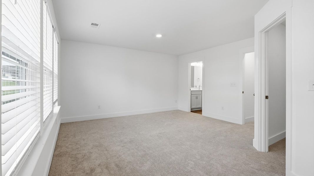 Elegant primary suite with natural light and walk-in closet in this top-notch Clayton Crossing villa