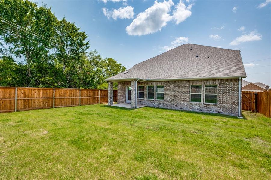 Rear view of property featuring a patio and a lawn