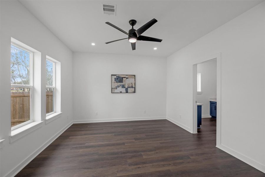 Brilliant, spacious room with large windows, sleek dark flooring, and a modern ceiling fan. Neutral walls are ready for personal touches, and the adjacent room offers additional space. Brilliant, spacious room with large windows, sleek dark flooring, and a modern ceiling fan. Neutral walls are ready for personal touches, and the adjacent room offers additional space.