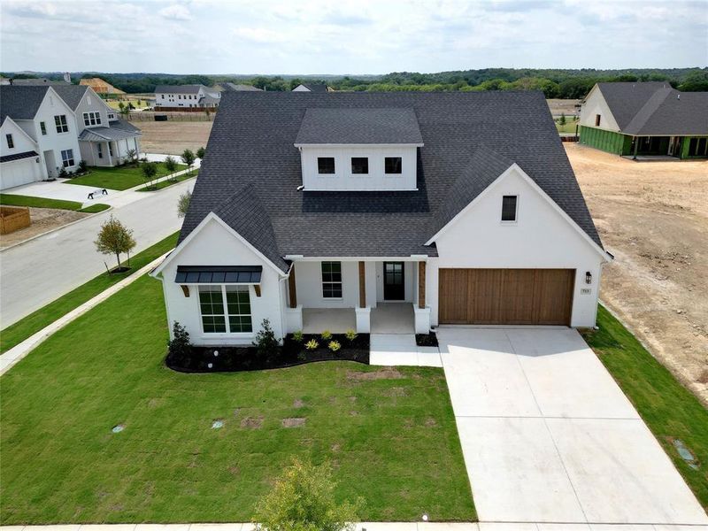 Modern farmhouse style home with a garage and a front yard