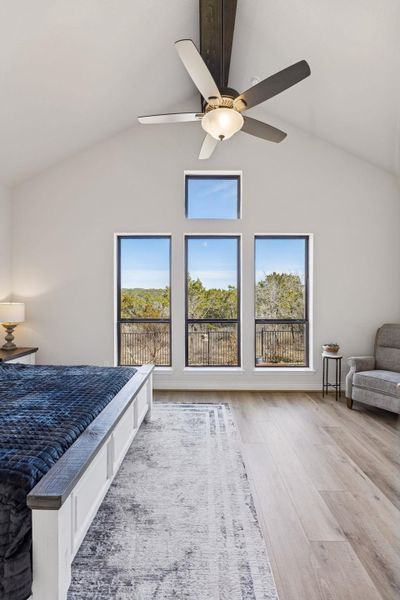 Beamed ceiling and picture windows in primary bedroom