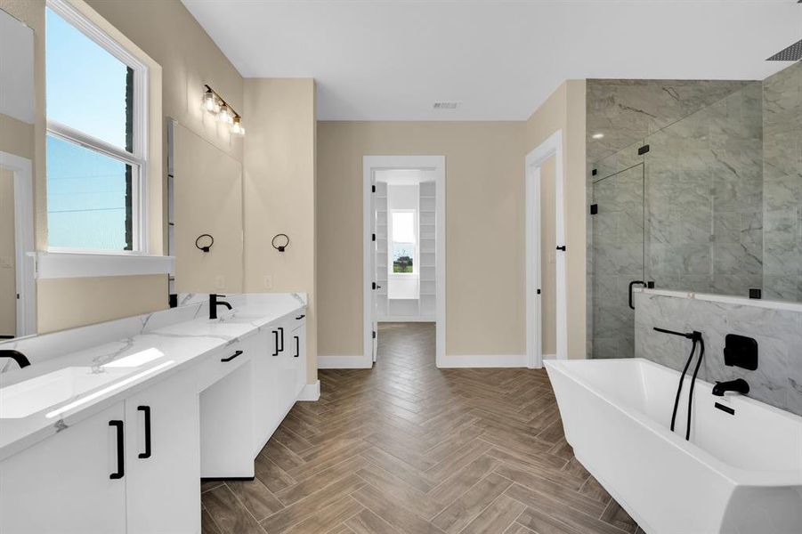 Bathroom featuring vanity, parquet floors, shower with separate bathtub, and a wealth of natural light