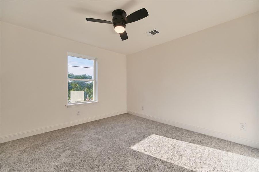 Carpeted spare room with ceiling fan