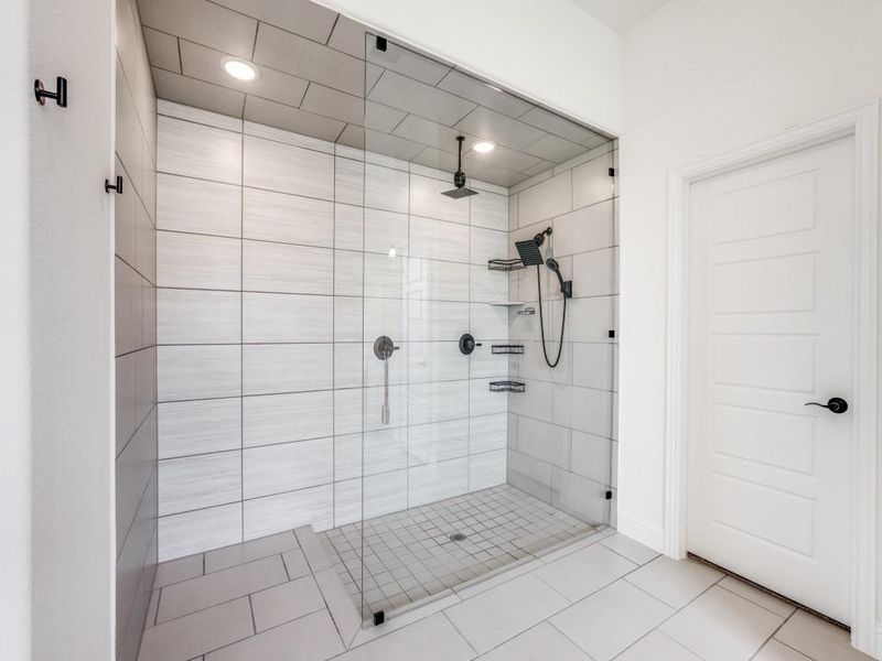 Bathroom featuring recessed lighting, tile patterned floors, and a shower stall Bathroom featuring recessed lighting, tile patterned floors, and a shower stall