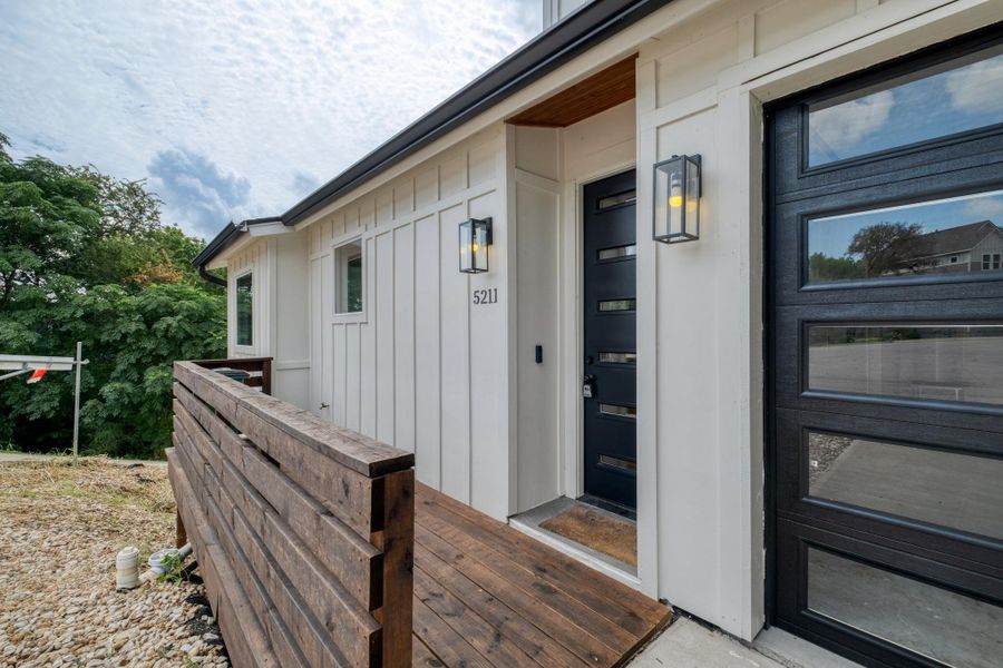 A modern facade with crisp white siding, contrasting black door and garage, and a warm wooden entry. A modern facade with crisp white siding, contrasting black door and garage, and a warm wooden entry.
