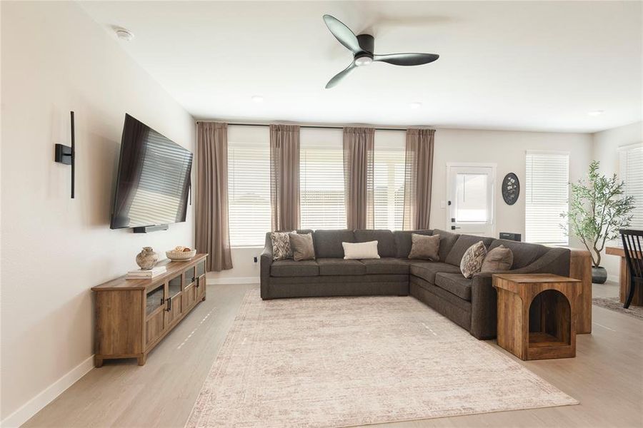 Open-concept living area featuring light wood-finish flooring, recessed lighting, and a contemporary ceiling fan Open-concept living area featuring light wood-finish flooring, recessed lighting, and a contemporary ceiling fan