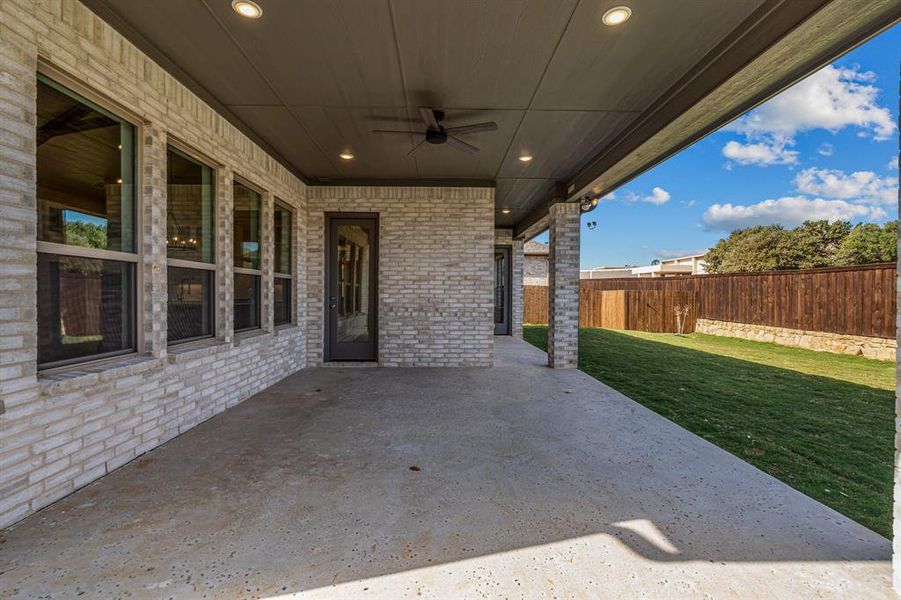 Fenced backyard featuring ceiling fan and a patio area