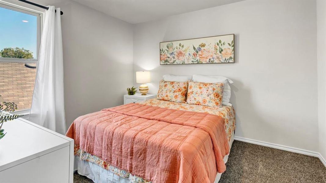 Bedroom featuring light gray walls and carpeted flooring Bedroom featuring light gray walls and carpeted flooring