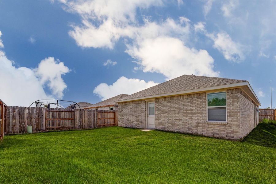 Rear exterior showcasing a spacious backyard with room to customize your own outdoor living space.