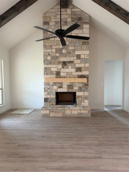 Large living with cathedral ceiling, stained beams and double back patio door