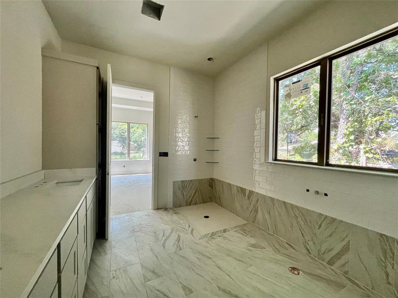 Bathroom with a wealth of natural light and tile patterned flooring