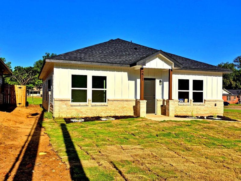 Back of house with a shingled roof, board and batten siding, and brick siding Back of house with a shingled roof, board and batten siding, and brick siding