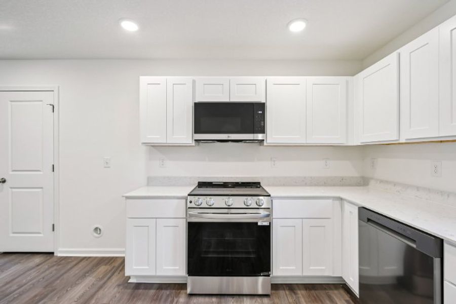 A kitchen with white cabinets.