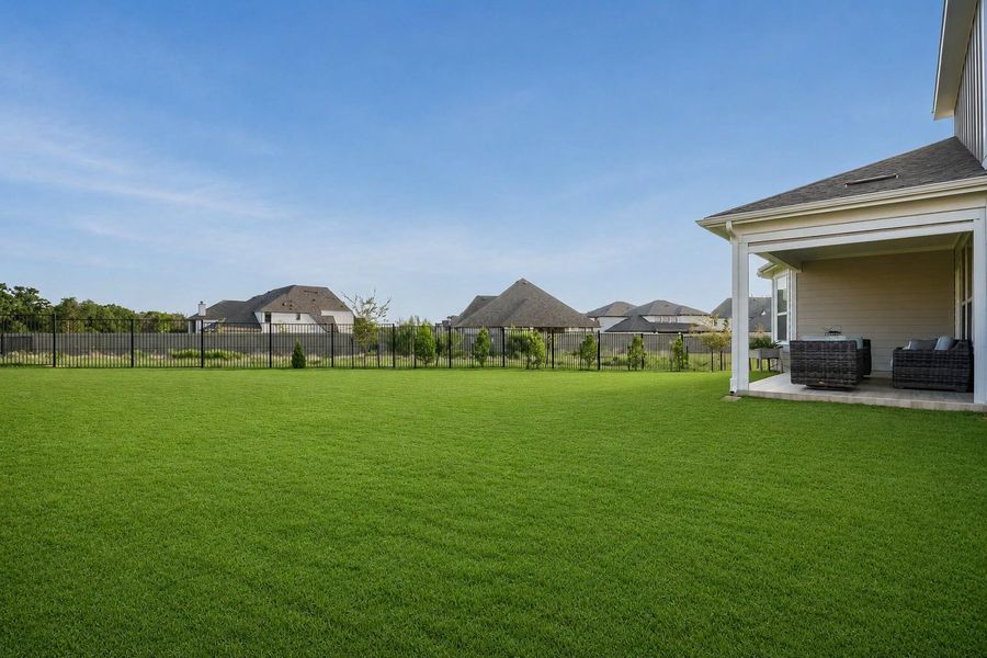 A spacious, verdant lawn perfect for outdoor living extends from the covered patio. A spacious, verdant lawn perfect for outdoor living extends from the covered patio.