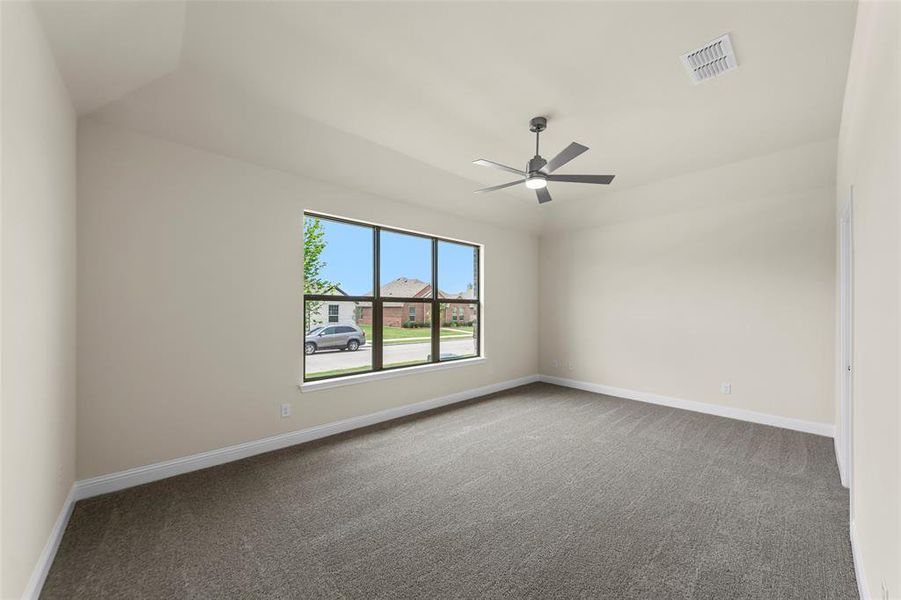 Spacious room featuring vaulted ceilings, neutral-toned walls, and plush carpeting