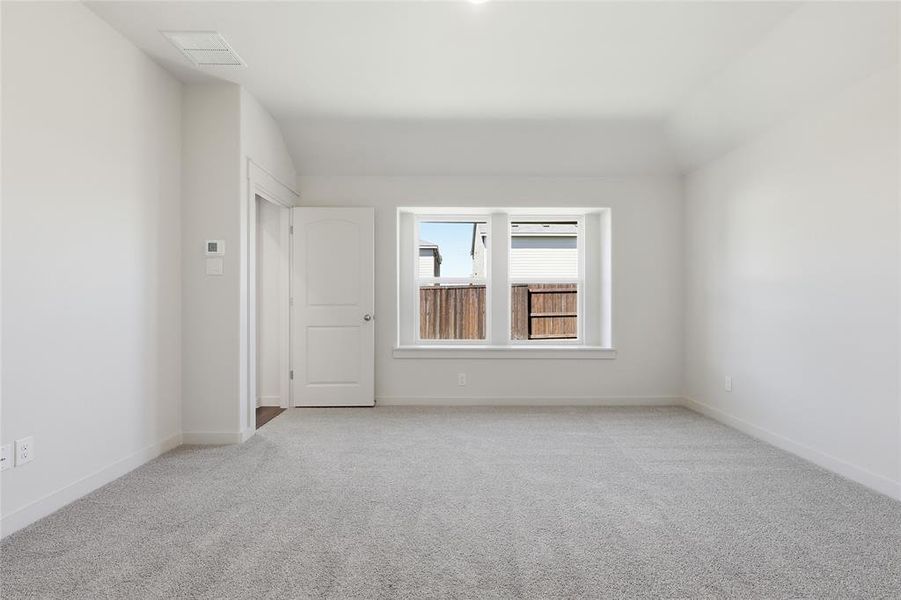 Spare room with light carpet and lofted ceiling
