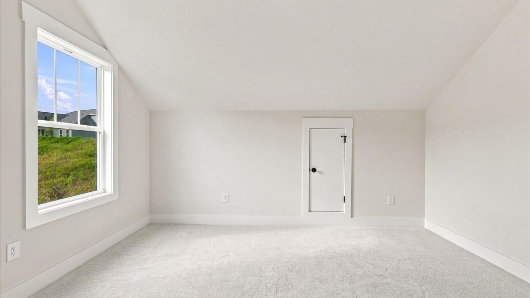 Notable bedroom offering soft carpet, a walk-in closet, and an expansive window overlooking the yard by DRB Homes