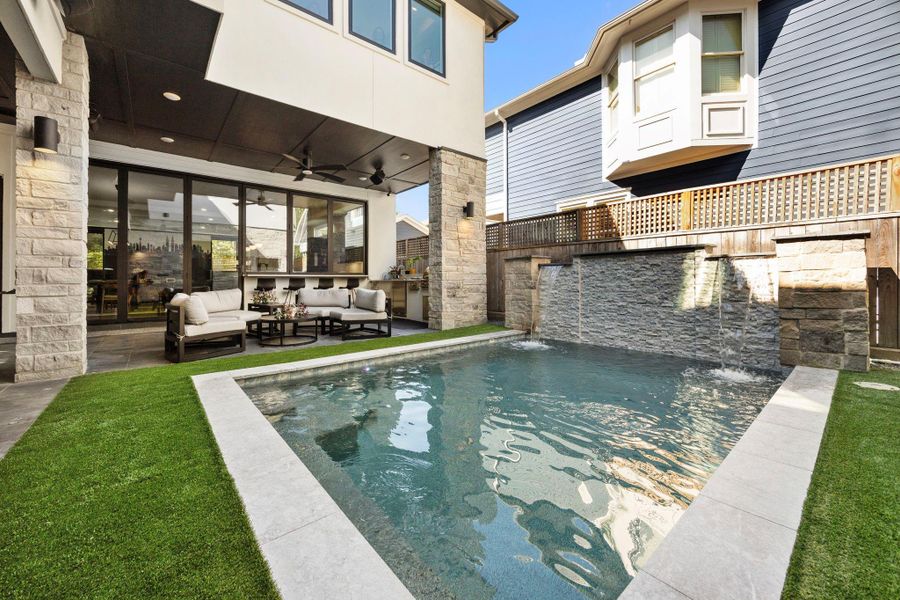 Gunite heated pool with low-maintenance artificial turf surround—perfect for year-round enjoyment.