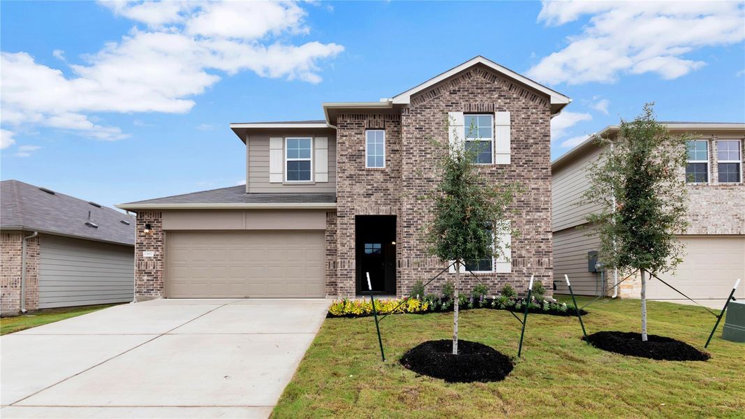 Front exterior of a new home in Carillon, Manor, TX, highlighting curb appeal (Image 2).