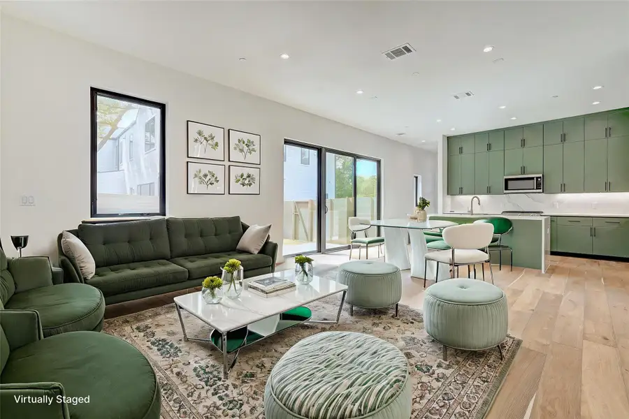 Living room with light wood-type flooring and recessed lighting