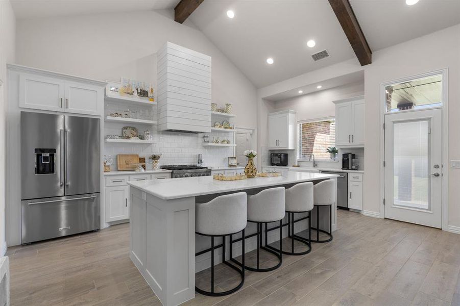 Kitchen featuring backsplash, white cabinets, beamed ceiling, recessed lighting, and high vaulted ceiling Kitchen featuring backsplash, white cabinets, beamed ceiling, recessed lighting, and high vaulted ceiling