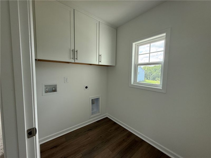 Functional laundry room offers upper cabinetry for Functional laundry room offers upper cabinetry for