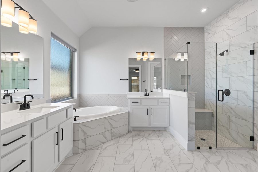 Bathroom with a shower stall, a bath, two vanities, and light marble finish flooring