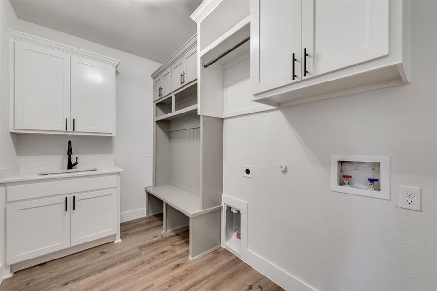 Laundry room with sink, light hardwood / wood-style flooring, electric dryer hookup, and washer hookup