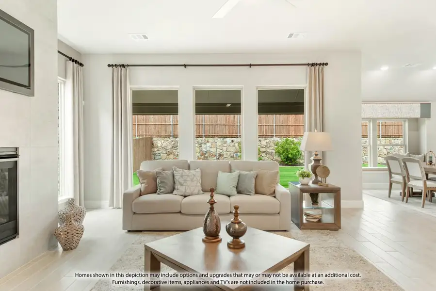 Bright living room with beige sofa, fireplace, large windows, and wood coffee table overlooking backyard Bright living room with beige sofa, fireplace, large windows, and wood coffee table overlooking backyard