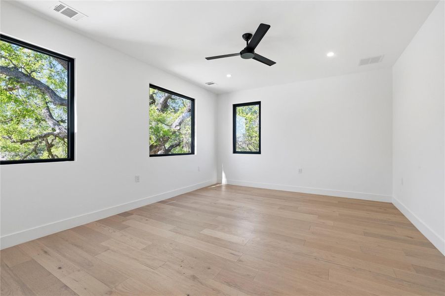 Empty room featuring light wood-style floors, a ceiling fan, and recessed lighting