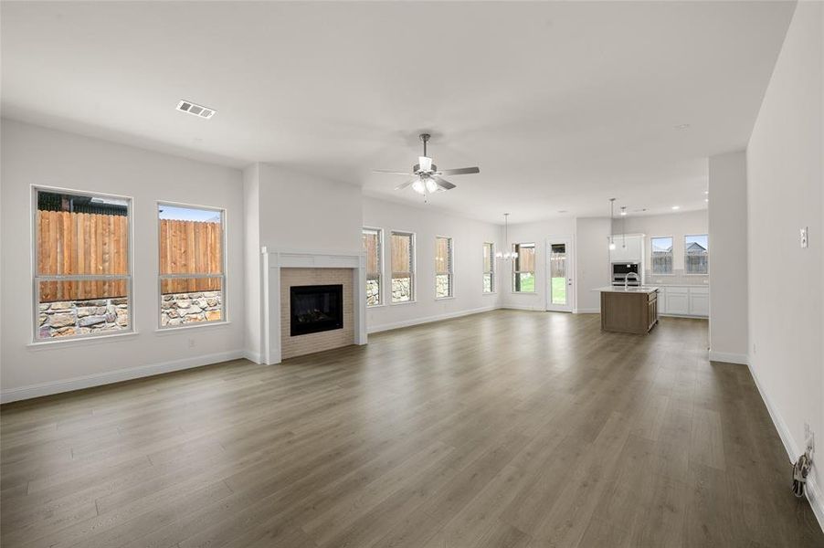 Unfurnished living room with ceiling fan, wood finished floors, a glass covered fireplace, and recessed lighting