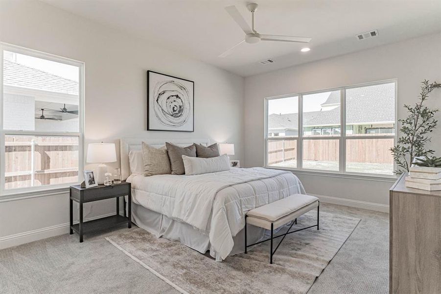 Carpeted bedroom featuring ceiling fan